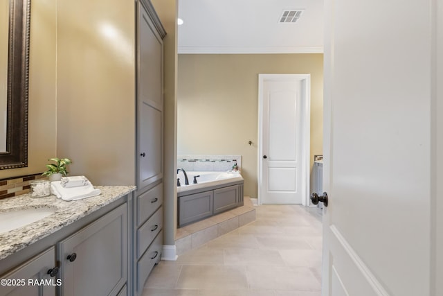 bathroom with a garden tub, visible vents, ornamental molding, and vanity