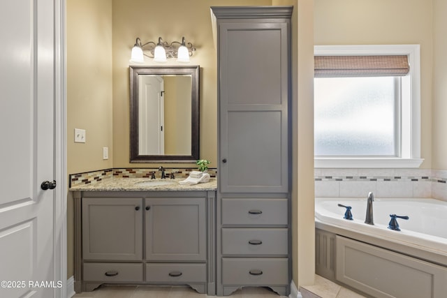 full bathroom with backsplash, vanity, and a bath