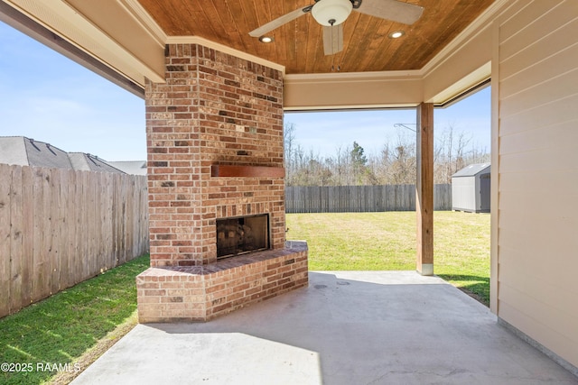 view of patio with ceiling fan, a storage shed, an outdoor brick fireplace, and a fenced backyard