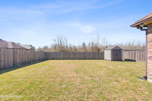 view of yard featuring an outbuilding, a fenced backyard, and a shed