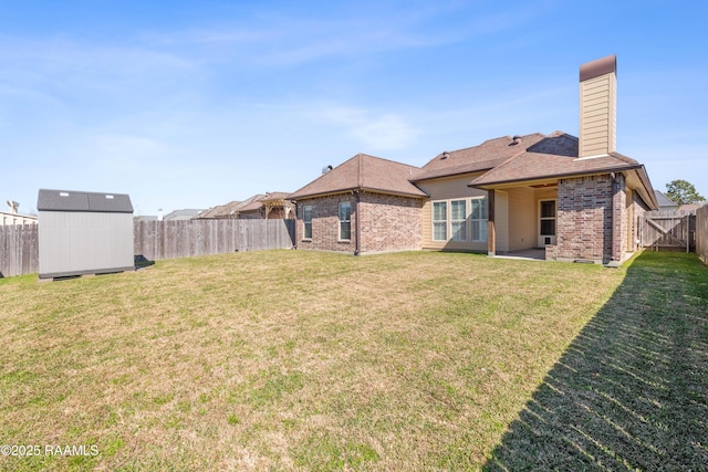 view of yard featuring an outbuilding, a patio area, a fenced backyard, and a storage unit