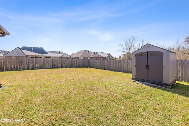 view of yard featuring an outbuilding, a shed, and a fenced backyard