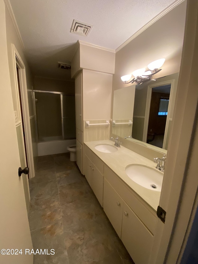 full bathroom featuring vanity, bath / shower combo with glass door, toilet, ornamental molding, and a textured ceiling