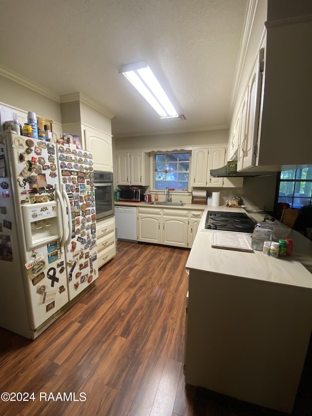 kitchen featuring dark wood-type flooring, appliances with stainless steel finishes, a textured ceiling, white cabinets, and ornamental molding