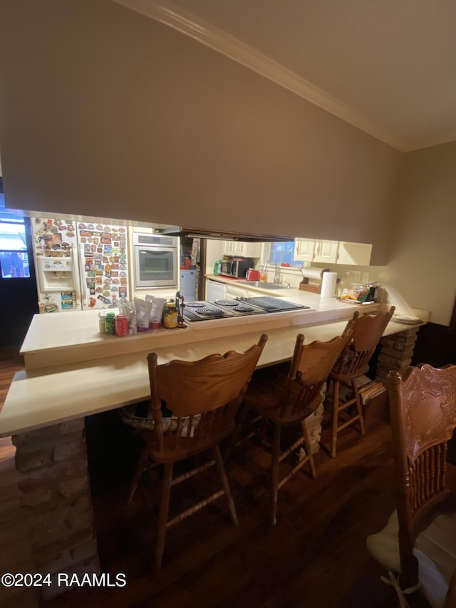 bar with stainless steel appliances, crown molding, and dark wood-type flooring