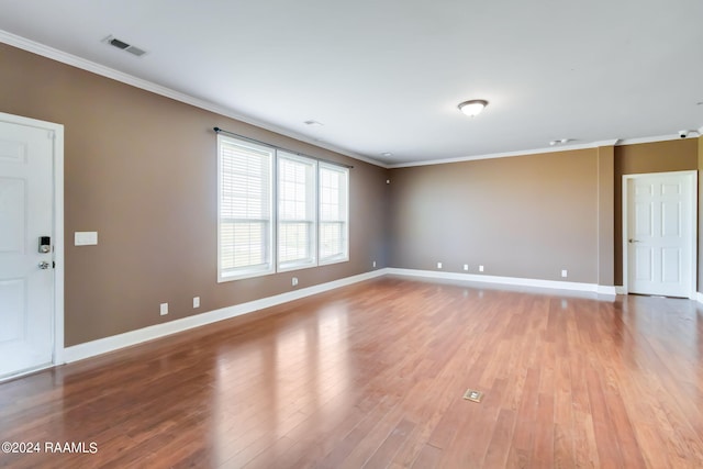 unfurnished room with light wood-type flooring and ornamental molding