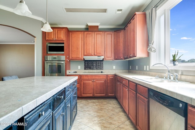 kitchen with ornamental molding, stainless steel appliances, sink, pendant lighting, and light tile patterned floors