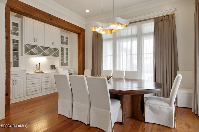 dining space featuring a chandelier, light hardwood / wood-style floors, and ornamental molding