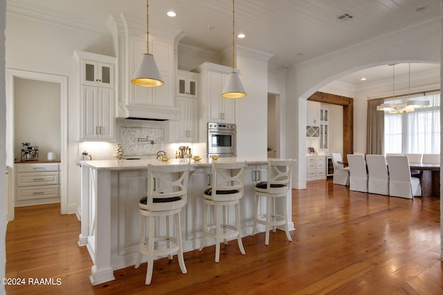 kitchen featuring crown molding, white cabinets, dark hardwood / wood-style floors, and decorative light fixtures