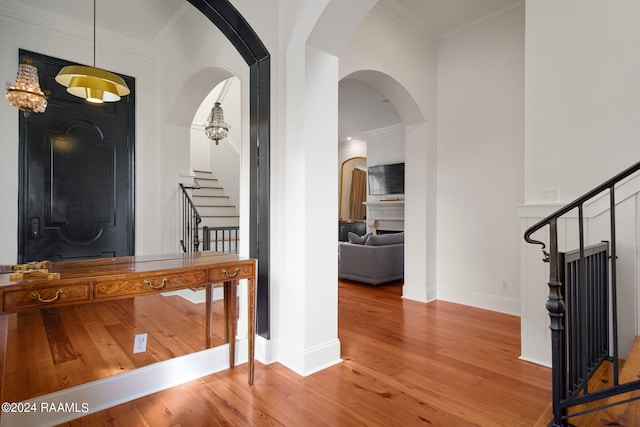 entrance foyer with hardwood / wood-style floors and crown molding