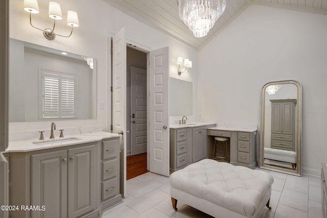 bathroom with vanity, tile patterned flooring, high vaulted ceiling, and an inviting chandelier