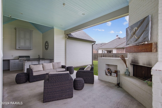 view of patio with an outdoor living space with a fireplace, grilling area, and exterior kitchen