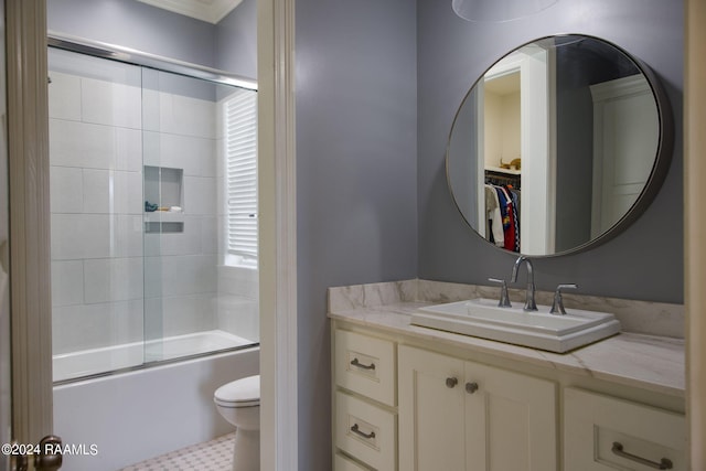 full bathroom featuring toilet, combined bath / shower with glass door, and vanity