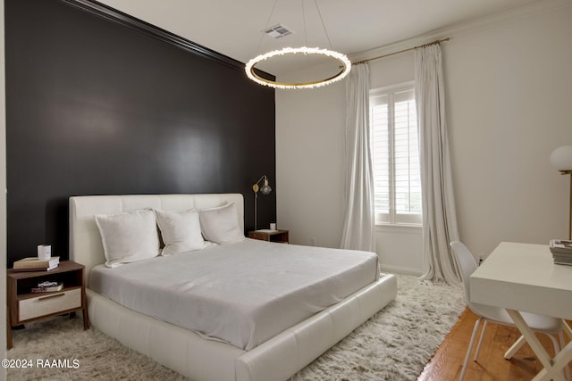 bedroom featuring light hardwood / wood-style flooring and ornamental molding