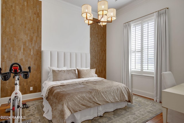 bedroom with a notable chandelier, wood-type flooring, and crown molding