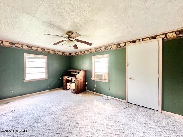 miscellaneous room featuring carpet, a textured ceiling, ceiling fan, and plenty of natural light