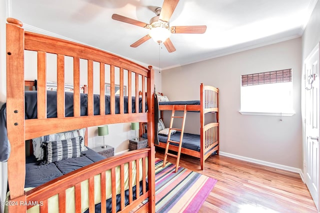 bedroom featuring ceiling fan, light wood-type flooring, and ornamental molding