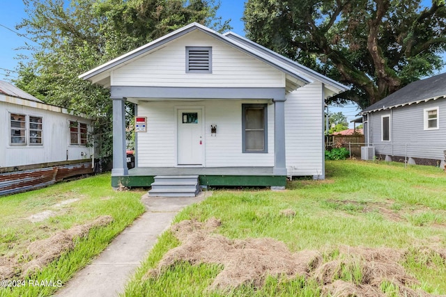 bungalow-style home with a front lawn and central air condition unit