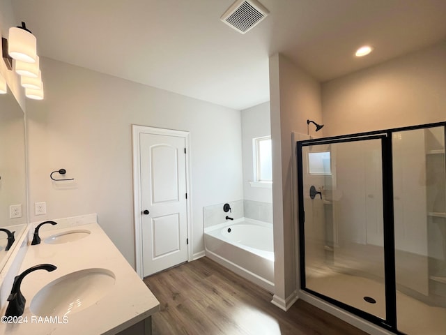 bathroom featuring vanity, hardwood / wood-style floors, and plus walk in shower