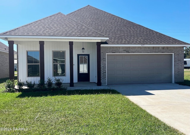 view of front facade with covered porch, a garage, and a front lawn