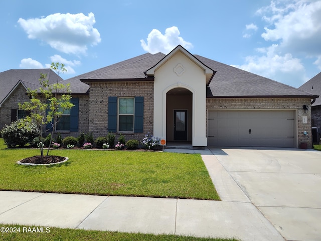 view of front of property featuring cooling unit, a garage, and a front yard