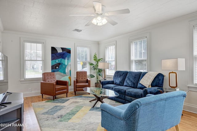 living room with ornamental molding, ceiling fan, and light wood-type flooring