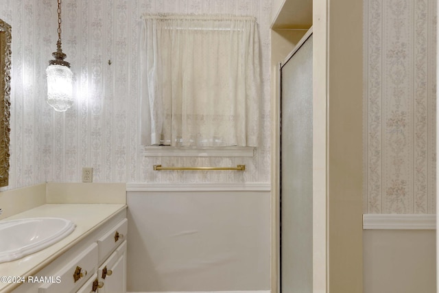 bathroom with vanity and a shower with door