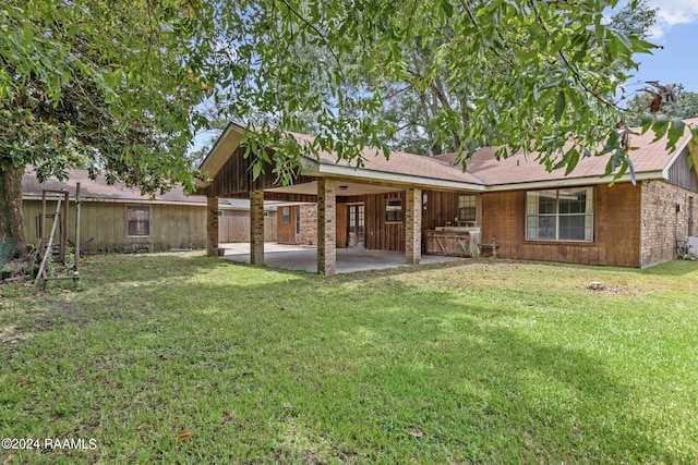 rear view of property featuring a patio area and a lawn