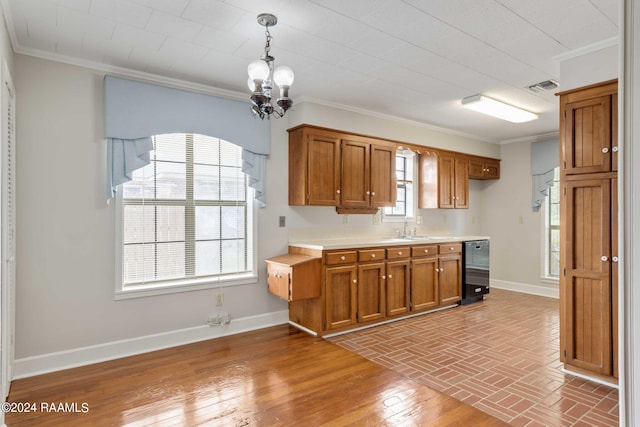 kitchen with crown molding, sink, pendant lighting, a notable chandelier, and black dishwasher