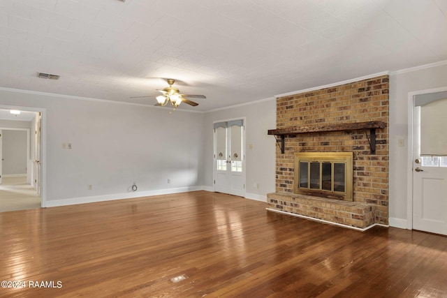 unfurnished living room with hardwood / wood-style flooring, ceiling fan, ornamental molding, and a brick fireplace