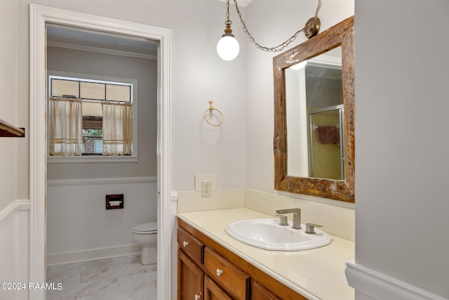 bathroom featuring vanity, toilet, and ornamental molding