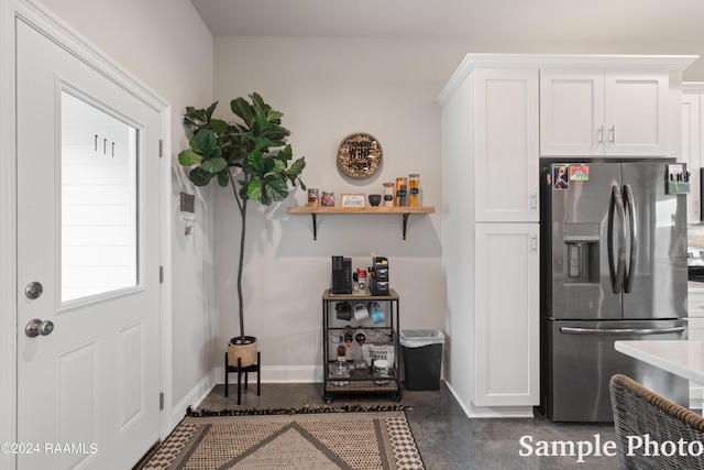 kitchen featuring white cabinets and stainless steel fridge with ice dispenser