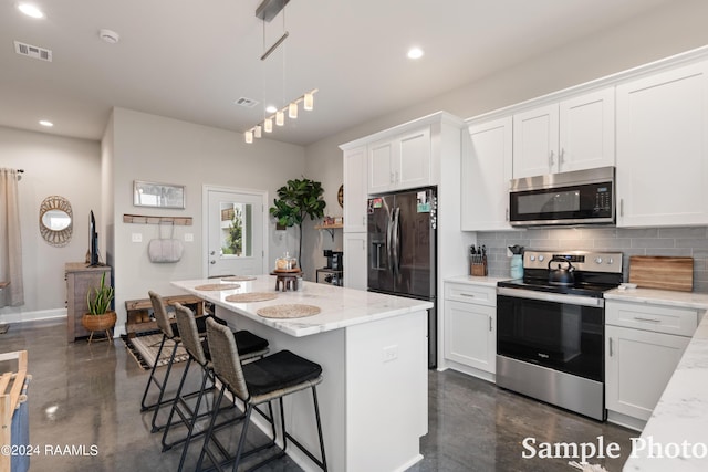 kitchen featuring white cabinetry, a kitchen island, pendant lighting, backsplash, and stainless steel appliances