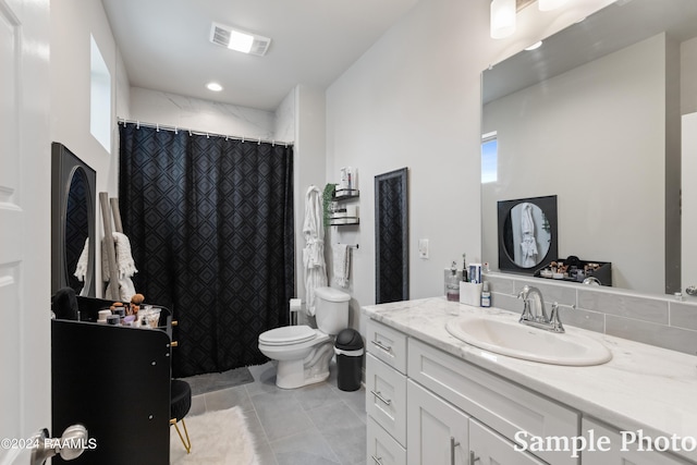 bathroom featuring toilet, tile patterned floors, and vanity