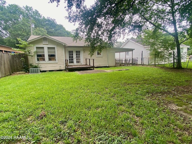 back of house with a yard, a deck, and cooling unit