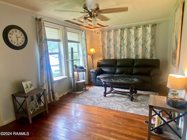 living room with hardwood / wood-style flooring, ceiling fan, and crown molding