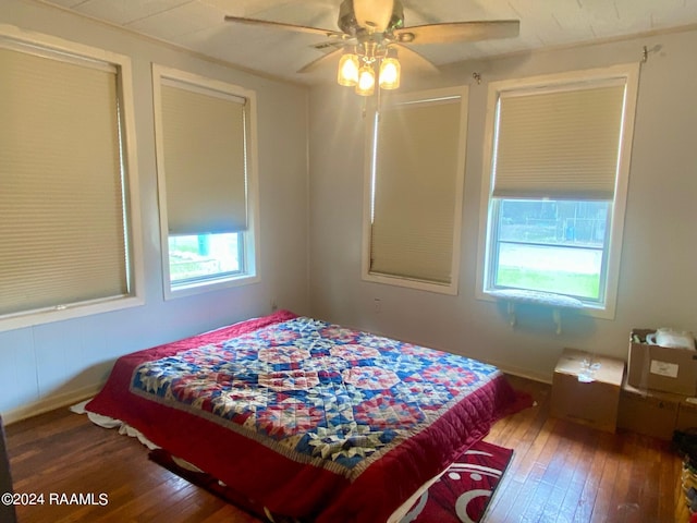 bedroom with hardwood / wood-style floors, ceiling fan, and multiple windows