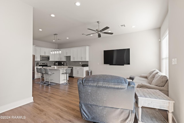 living room with ceiling fan and wood-type flooring