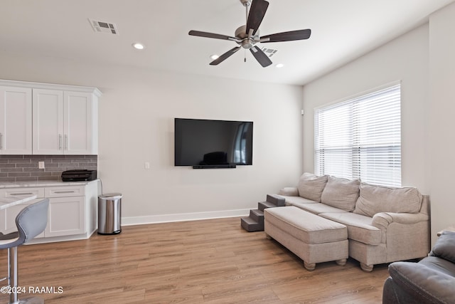 living room with light hardwood / wood-style floors and ceiling fan