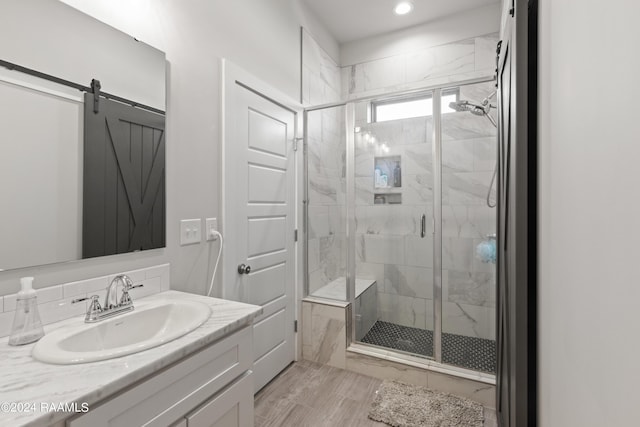 bathroom with a shower with door and vanity