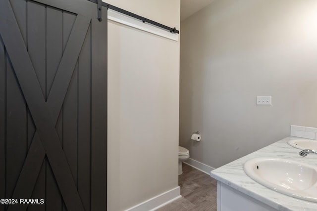 bathroom featuring wood-type flooring, toilet, and vanity