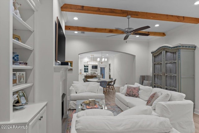 living room with light hardwood / wood-style floors, ceiling fan with notable chandelier, and ornamental molding