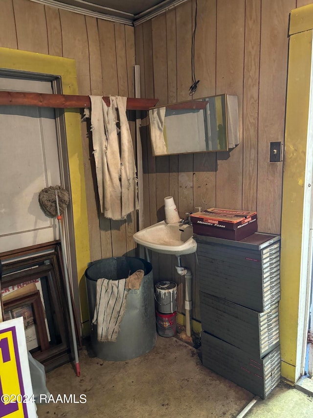 bathroom with wooden walls and concrete floors