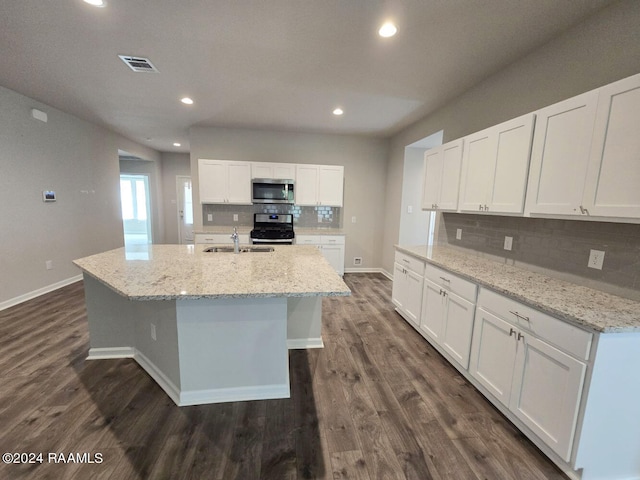 kitchen with white cabinetry, dark wood-type flooring, appliances with stainless steel finishes, an island with sink, and tasteful backsplash