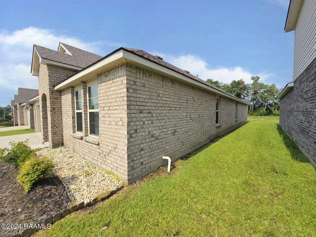 view of property exterior featuring a garage and a lawn