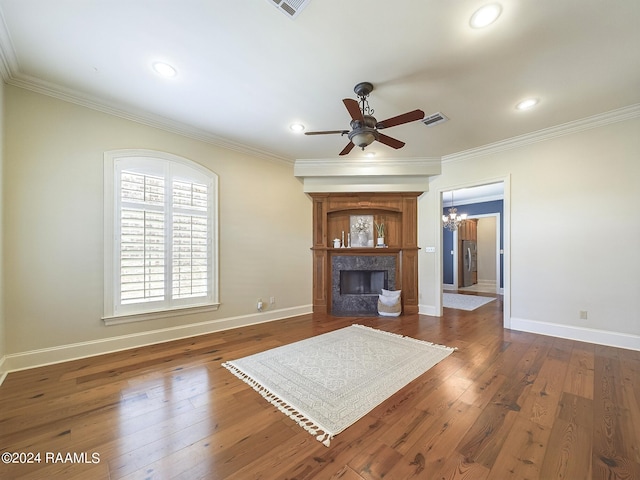 unfurnished living room with crown molding, ceiling fan with notable chandelier, and dark wood-type flooring