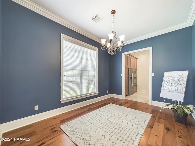 interior space featuring ornamental molding, a chandelier, and light hardwood / wood-style floors