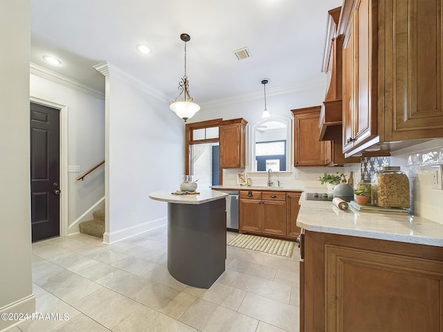 kitchen with crown molding, hanging light fixtures, a kitchen island, light stone countertops, and backsplash