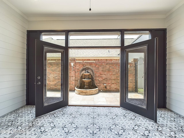 entryway featuring french doors, ornamental molding, and wood walls