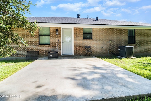 view of front of house with central air condition unit and a patio area